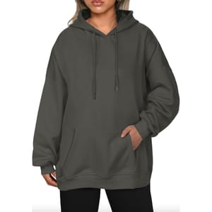 A dark gray oversized hoodie featuring a front pocket, drawstrings, and a relaxed fit.