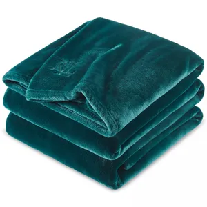 A folded, teal, plush blanket featuring an embossed logo on the corner.