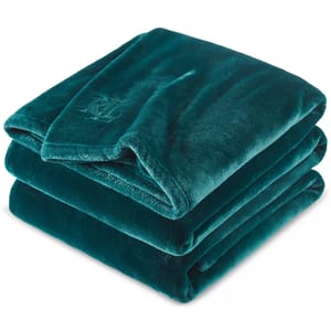 A folded, teal, plush blanket featuring an embossed logo on the corner.