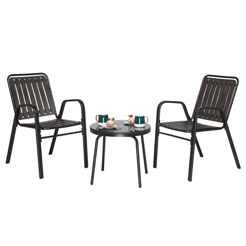 Two black metal chairs with vertical slat backs and a matching small round table with two cups and a plant on top.