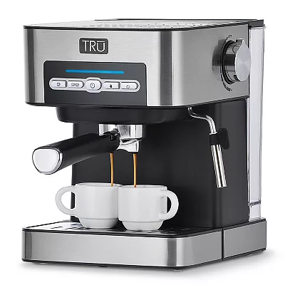 A stainless steel TRU espresso machine with 15-bar pressure, a steam wand, and digital controls, dispensing coffee into two small cups.