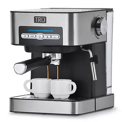 A stainless steel TRU espresso machine with 15-bar pressure, a steam wand, and digital controls, dispensing coffee into two small cups.