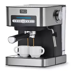 A stainless steel TRU espresso machine with 15-bar pressure, a steam wand, and digital controls, dispensing coffee into two small cups.