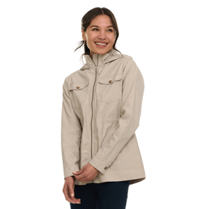 A woman wearing a light beige hooded jacket with buttoned chest pockets and a front zipper, paired with dark pants.