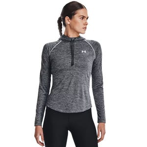 A woman wearing a long-sleeve, dark gray athletic hoodie with a front zipper and black leggings.