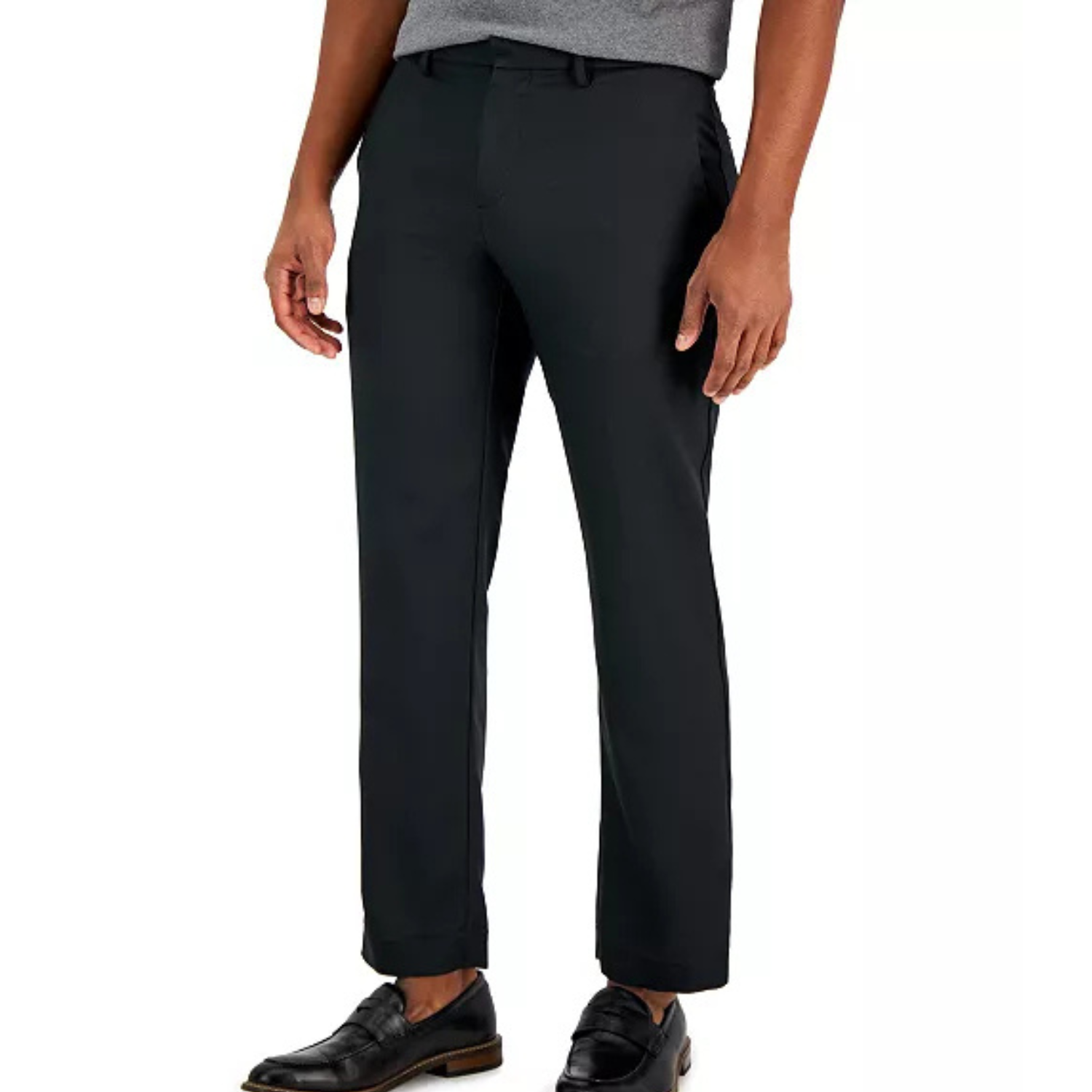 A pair of black dress pants worn by a model, paired with black loafers and a gray shirt.