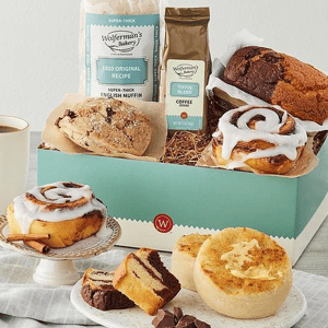A selection of baked goods, including English muffins, cinnamon rolls, and a loaf cake, alongside a bag of coffee.