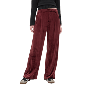 High-waisted, wide-leg, crinkle velvet trousers in a rich burgundy color, featuring pleats and a zip closure, paired with a black sweater and sneakers.