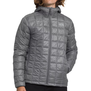 The North Face ThermoBall Puffer Jacket is a lightweight, gray, hooded jacket with a quilted design. It features a full-length front zipper and side pockets, providing both comfort and warmth.