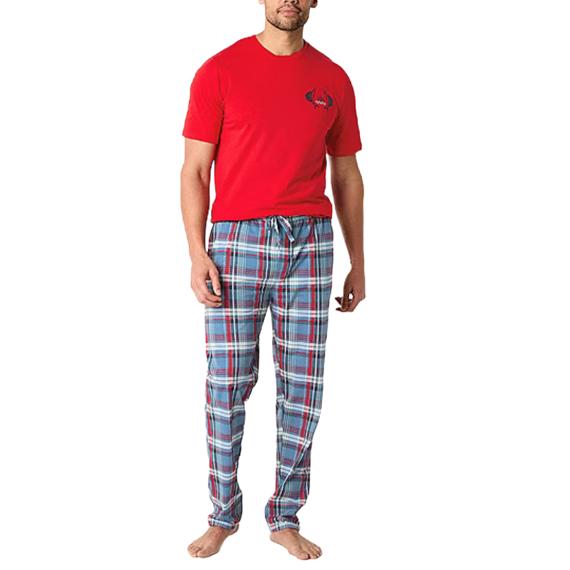 A man is wearing a red T-shirt and blue plaid pajama pants with a drawstring, standing barefoot.