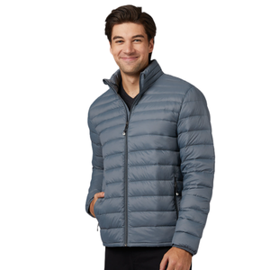 A man is wearing a gray, quilted down jacket with a zip closure, high collar, and hands in pockets.