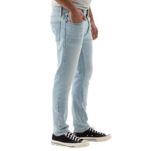 A pair of light blue Gap Factory men's jeans with a classic five-pocket design, paired with black and white sneakers.