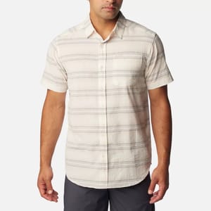A man wearing a short-sleeved, button-up shirt with horizontal stripes.