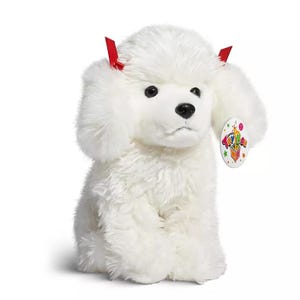 A plush toy resembling a white dog with fluffy fur and small red devil horns.