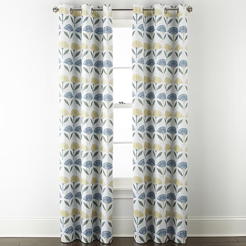 Pair of curtains with a modern floral pattern featuring blue and yellow stylized flowers on a white background, hanging on a metal rod.