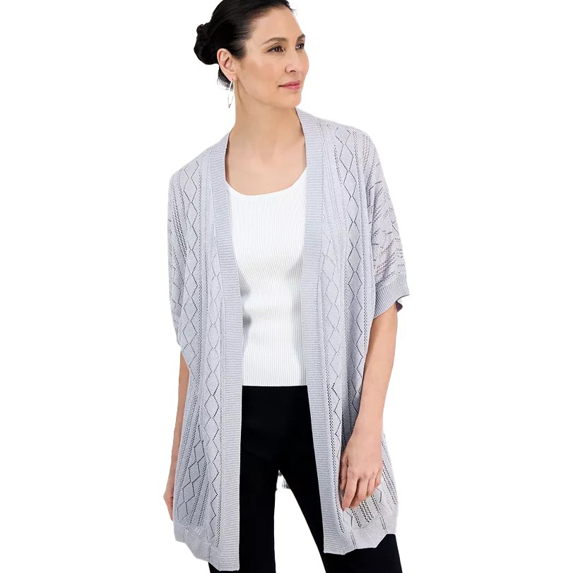 Woman wearing a light gray open-front cardigan with a diamond knit pattern over a white top and black pants.