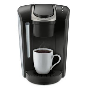 A single-serve coffee maker with a white mug of coffee.