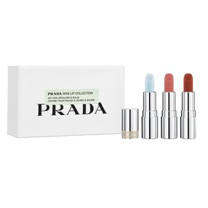 Prada Mini Lip Collection set includes three lip colors and a balm, each in sleek silver packaging. The colors range from light blue to soft pink and deep red.