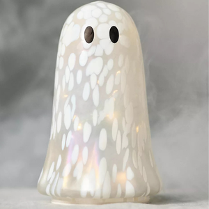 A decorative ghost-shaped figure with a white, speckled pattern and two black eyes, illuminated from within. The surface has a glossy finish.