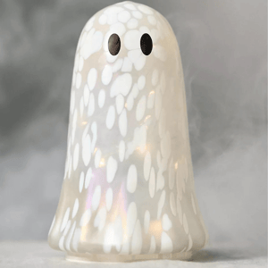 A decorative ghost-shaped figure with a white, speckled pattern and two black eyes, illuminated from within. The surface has a glossy finish.