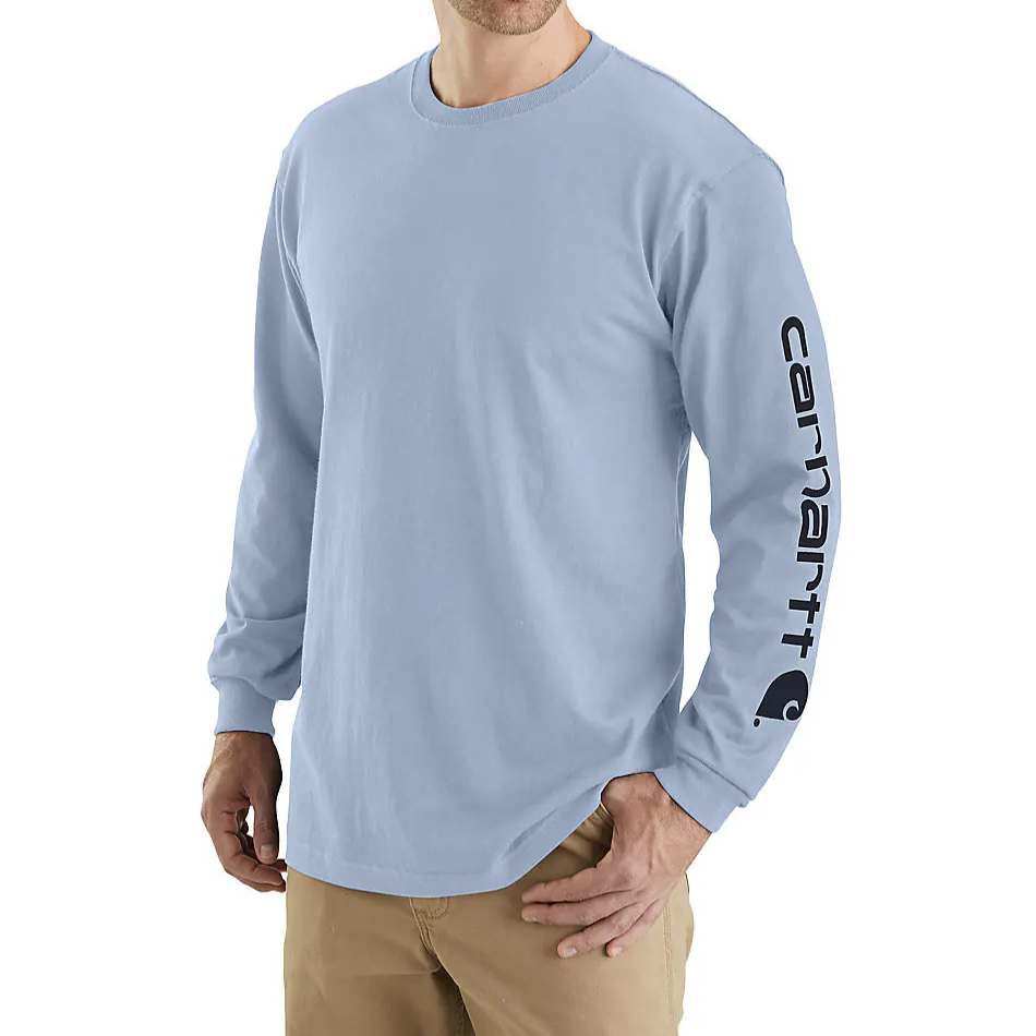 A person wearing a light blue long-sleeve shirt with black lettering running down the left arm.