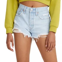 A person wearing light blue distressed denim shorts with frayed hems and a yellow cropped long-sleeve top.