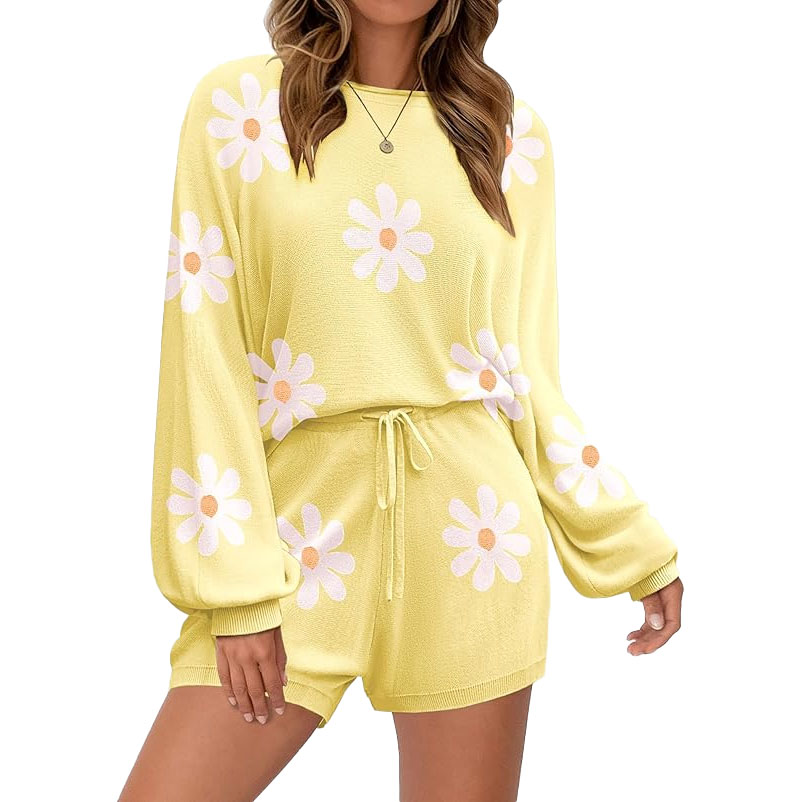 Yellow knit lounge set with long sleeves and shorts, featuring white daisy patterns with pink centers. The top has a relaxed fit, and the shorts have an elastic waistband with a drawstring.