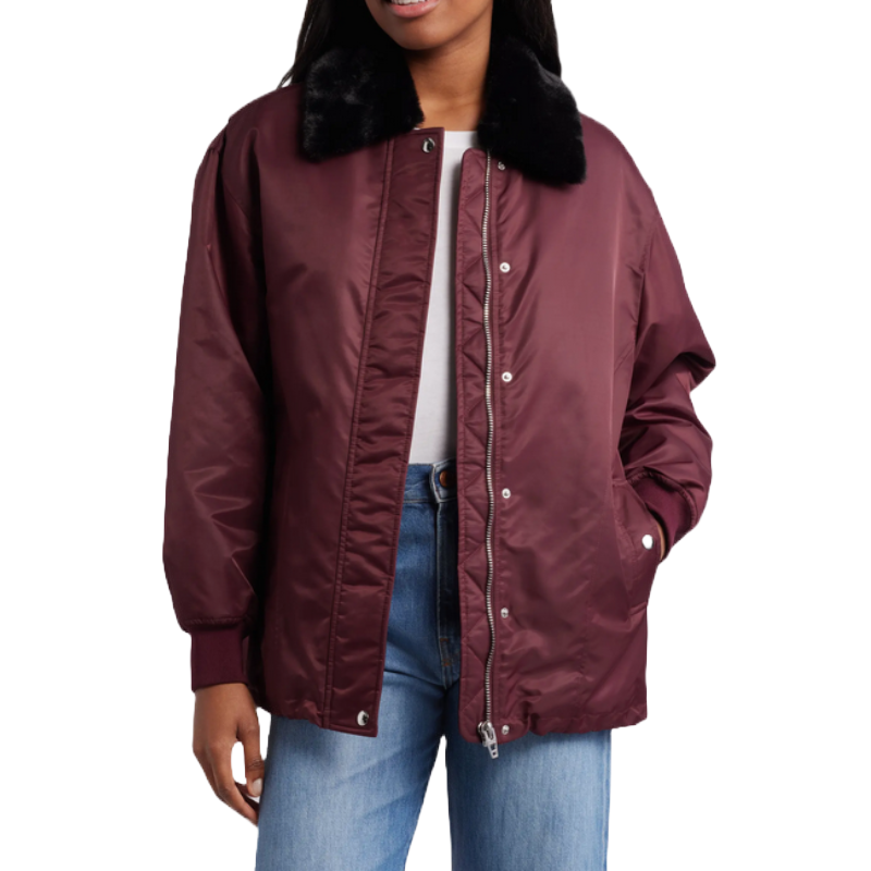 A maroon bomber jacket with a black faux fur collar, snap button closure, and side pockets, paired with blue jeans and a white top.