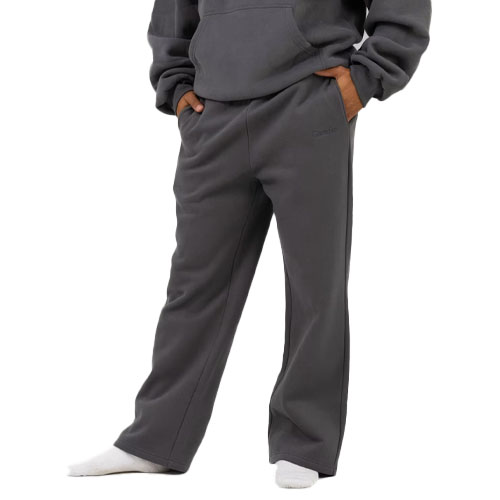A person wearing dark gray fleece sweatpants with pockets, paired with a matching hoodie and white socks.