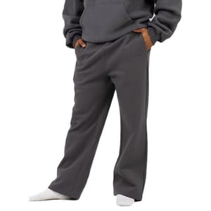 A person wearing dark gray fleece sweatpants with pockets, paired with a matching hoodie and white socks.
