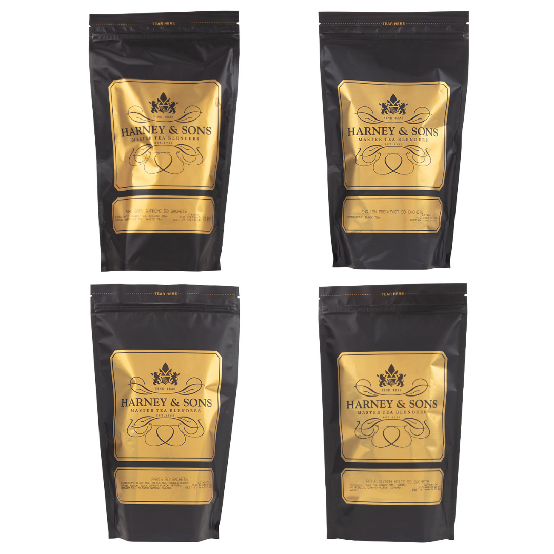 Four Harney & Sons tea blends in black and gold pouches. Varieties include Grey Supreme, English Breakfast, Paris, and Hot Cinnamon Spice, each containing 50 sachets.