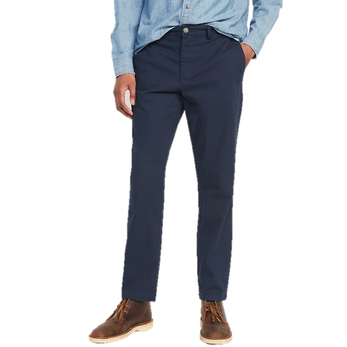 A person wears navy blue chinos, light blue button-up shirt, and brown leather boots.