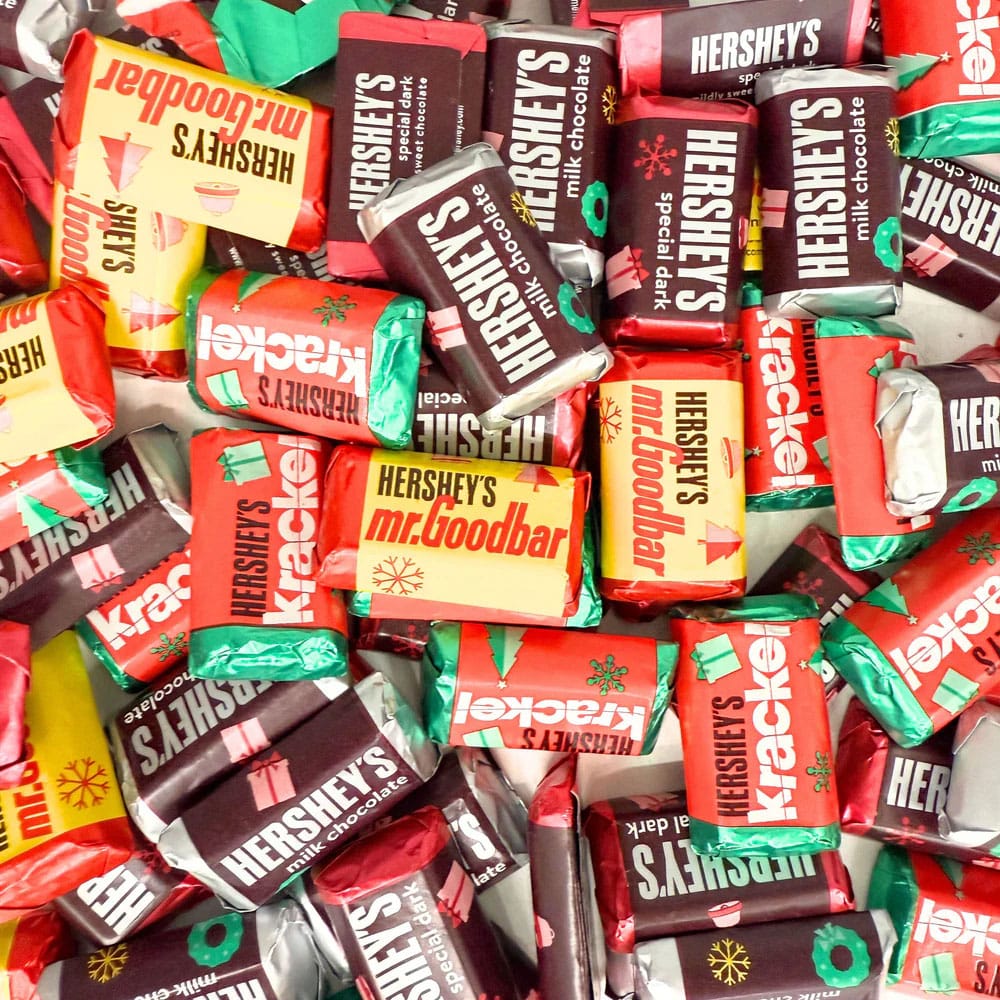 Assorted Hershey's Miniatures candies with wrappers featuring designs for Milk Chocolate, Special Dark, Krackel, and Mr. Goodbar, decorated in festive holiday colors and patterns.