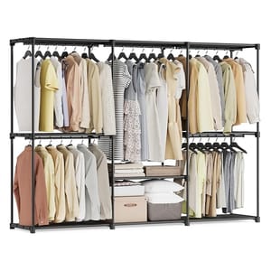 A freestanding wardrobe with a metal frame features clothing on hangers, multiple storage shelves, folded clothes, and boxes.