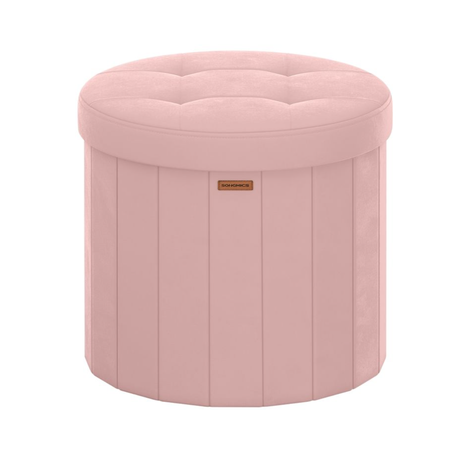 Round pink ottoman with tufted top, vertical seams, and a small label in the front.
