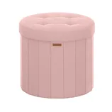 Round pink ottoman with tufted top, vertical seams, and a small label in the front.
