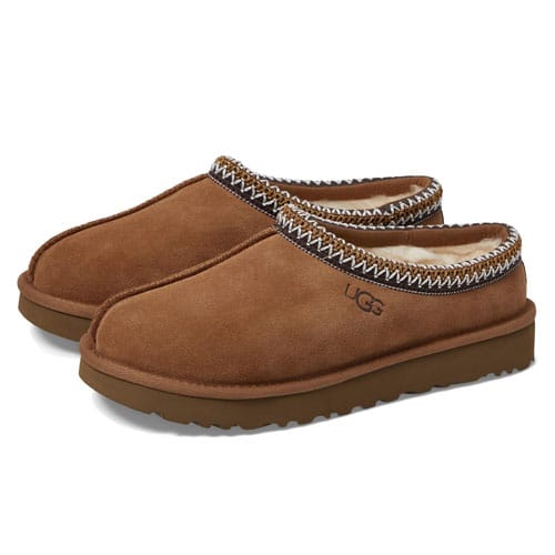 UGG Tasman Slippers are brown suede clogs with a thick rubber sole and a plush wool lining, featuring a woven braid detail along the top edge.