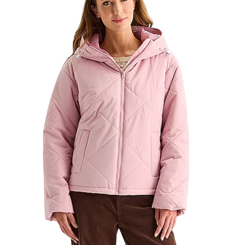 A woman wearing a light pink quilted hooded jacket with front pockets and a front zipper, paired with brown pants.