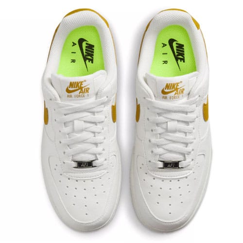 A pair of white Nike Air Force sneakers with yellow and light green accents.