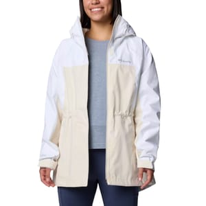 A woman is wearing a Columbia two-tone jacket in white and beige with a hood, over a gray shirt and dark pants.