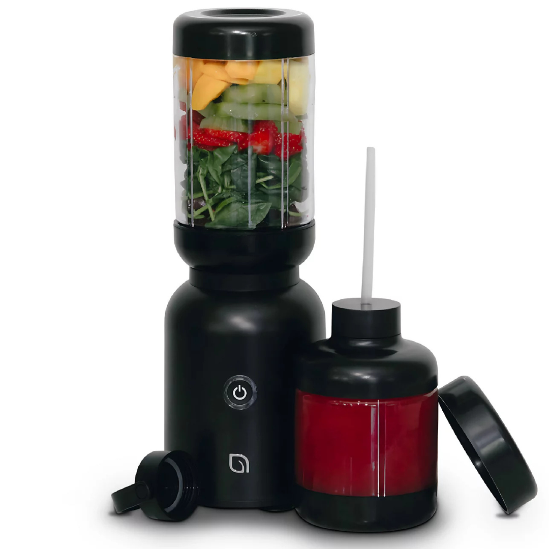 Compact black portable blender with fruits and greens inside, accompanied by an additional container with a red liquid and drinking straw.