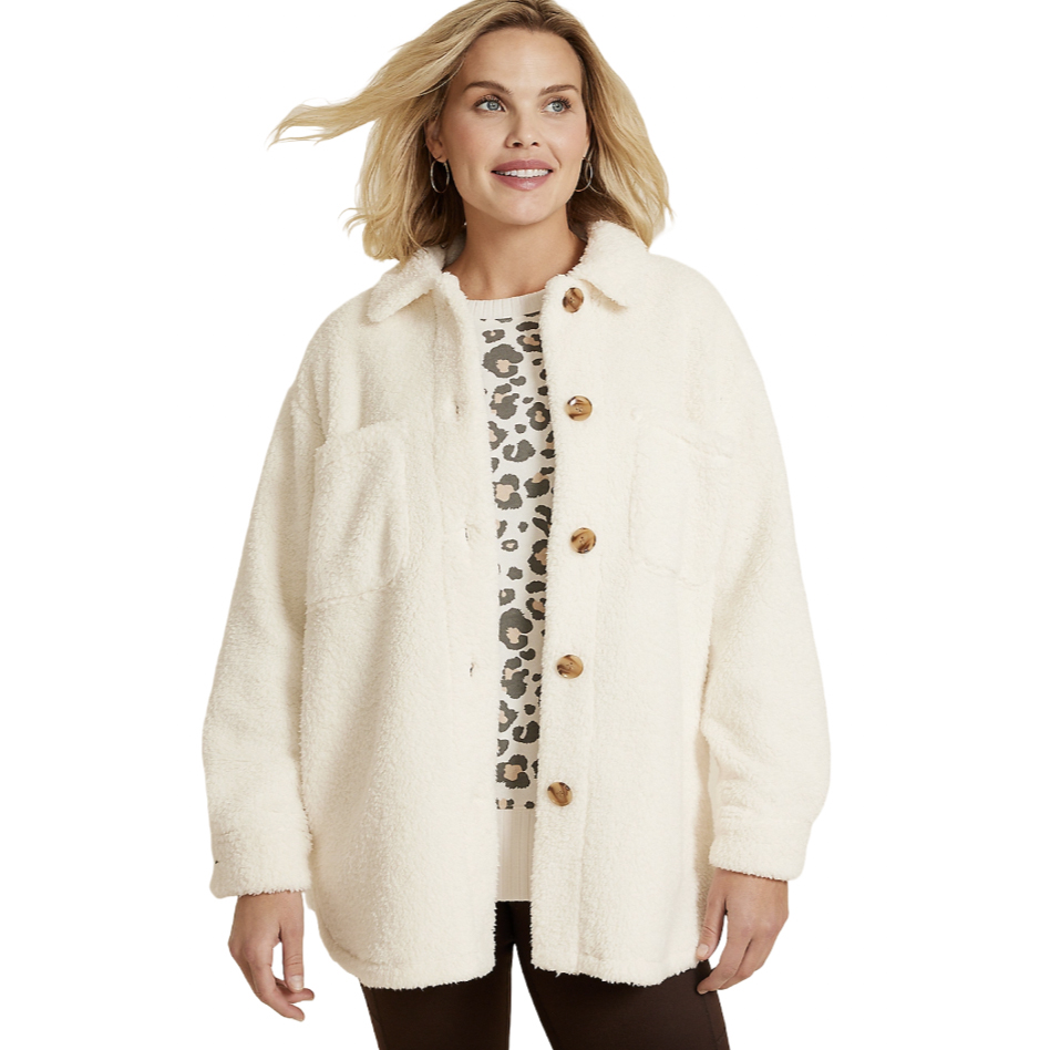 A woman wears a cream-colored sherpa jacket with large buttons and dual chest pockets over a leopard print top, paired with dark pants. The jacket has a casual, cozy look suitable for cooler weather.
