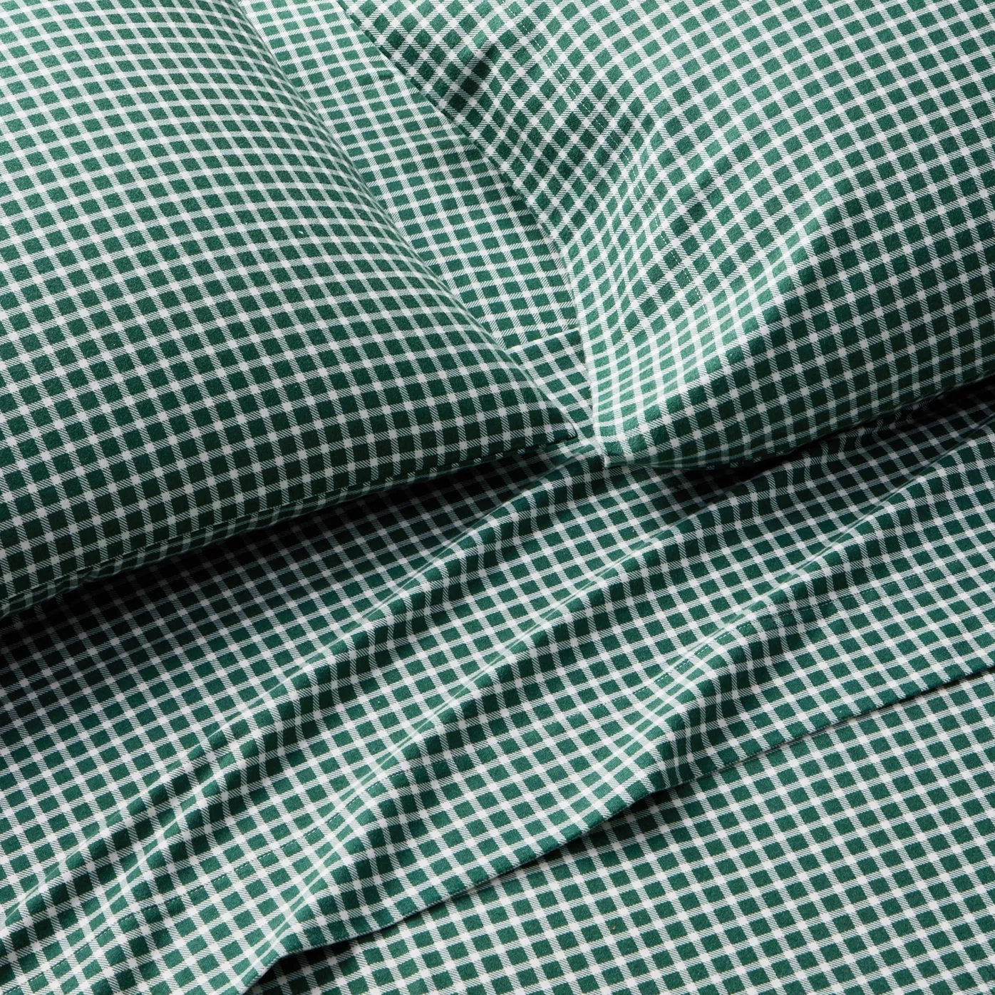 Green and white gingham pattern bedding set, including a pillowcase and sheet.