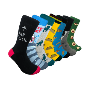 A set of 3 pairs of men's novelty socks featuring fun designs: one pair with a \“MR COOL\“ text, another with tacos, and a third with avocados. Each sock has vibrant colors and playful themes.