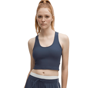 A woman in a dark blue ribbed crop tank top with scoop neckline and matching drawstring shorts, featuring a white waistband.