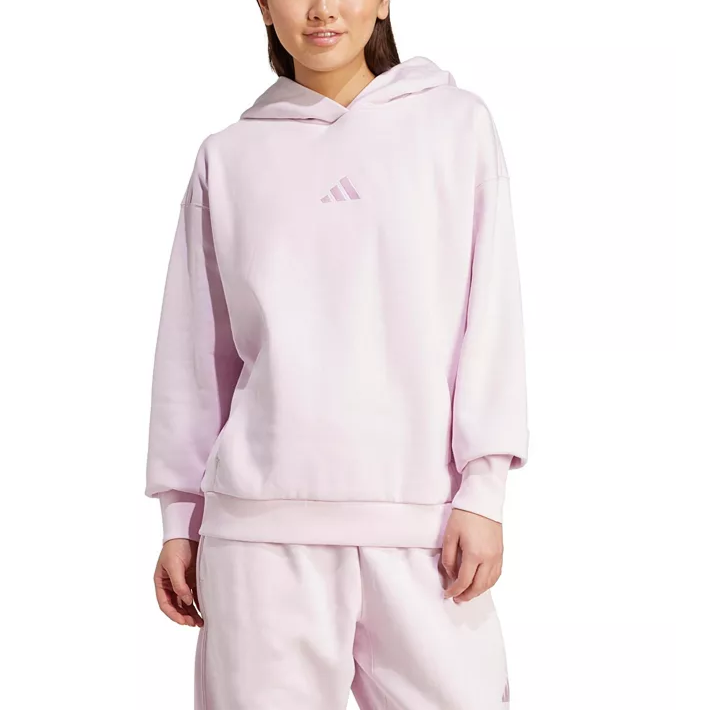 A person is wearing a light pink Adidas hoodie and matching sweatpants. The hoodie features the Adidas logo on the front.
