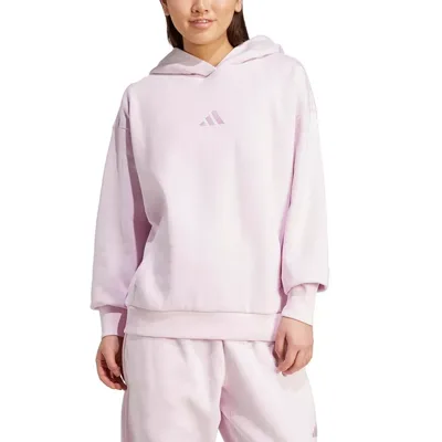 A person is wearing a light pink Adidas hoodie and matching sweatpants. The hoodie features the Adidas logo on the front.