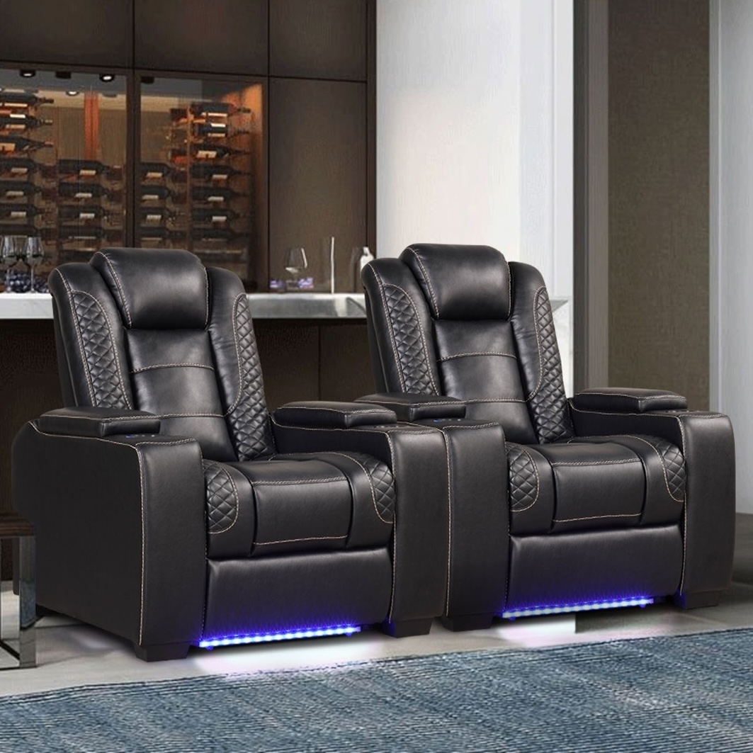 Two black leather recliners with diamond stitching, illuminated by blue LED lights, are placed in a modern room with a minimalist aesthetic.