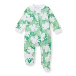 Green baby sleeper with white shamrock patterns, featuring a bee design on one foot.