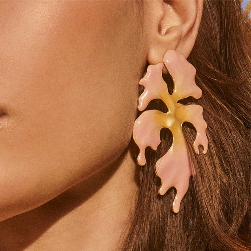 The Savannah Statement Earrings feature a large, abstract leaf shape in blended pink and yellow tones, designed to dangle elegantly from the ear.